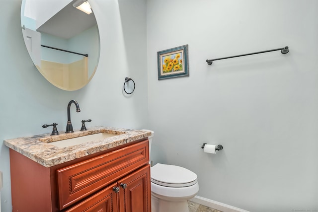 bathroom featuring baseboards, vanity, and toilet