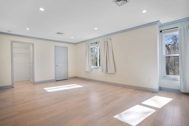 unfurnished bedroom with light wood finished floors, multiple windows, and visible vents