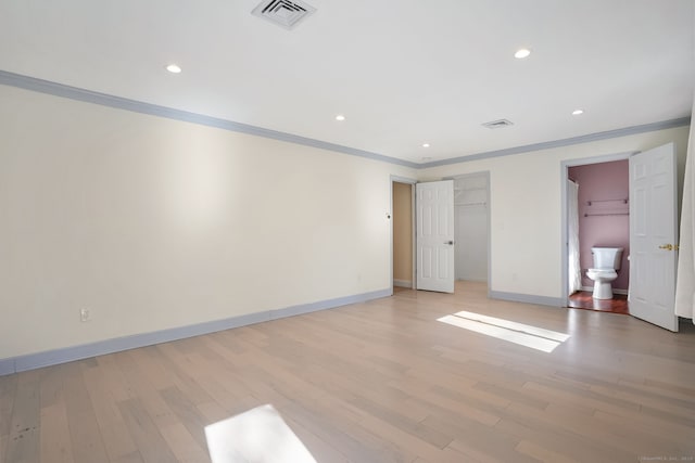 unfurnished bedroom with light wood finished floors, baseboards, visible vents, and crown molding