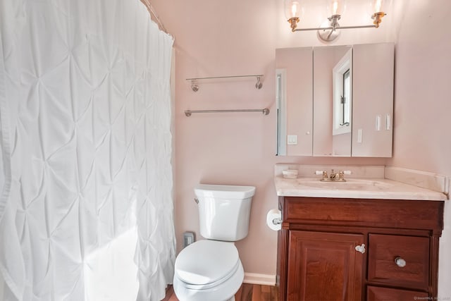 bathroom featuring curtained shower, vanity, and toilet