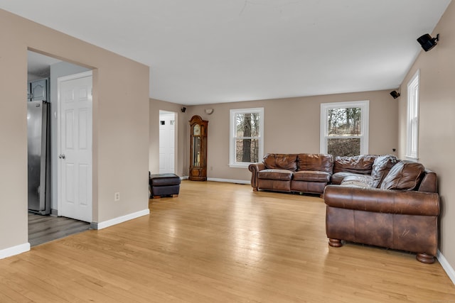 living area featuring light wood-style flooring and baseboards