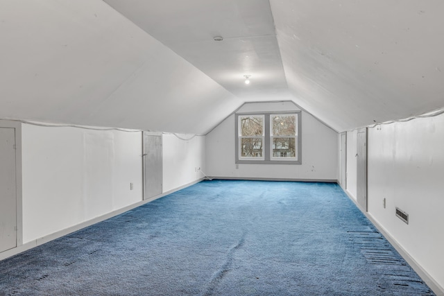 additional living space with lofted ceiling, visible vents, and carpet floors