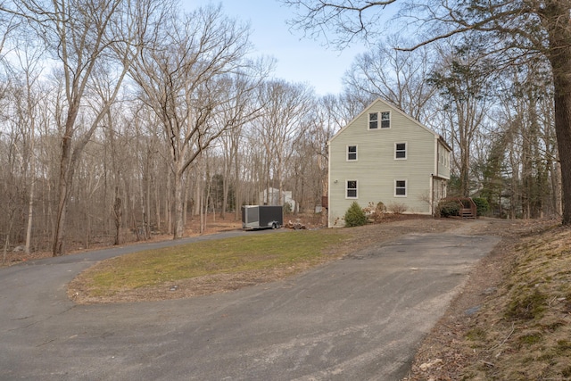 view of home's exterior with aphalt driveway and central air condition unit