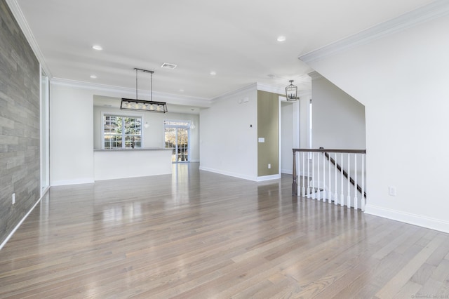 interior space with crown molding, a notable chandelier, and wood finished floors