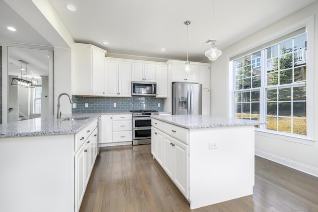 kitchen with visible vents, dark wood-style flooring, a sink, appliances with stainless steel finishes, and tasteful backsplash