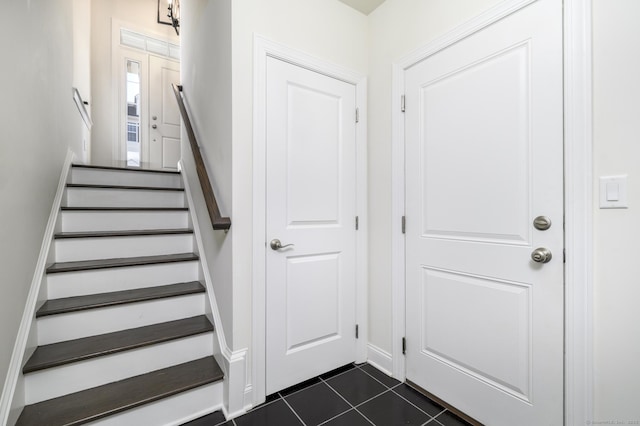 stairway with tile patterned floors and baseboards