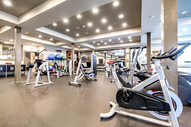 workout area with recessed lighting and a tray ceiling