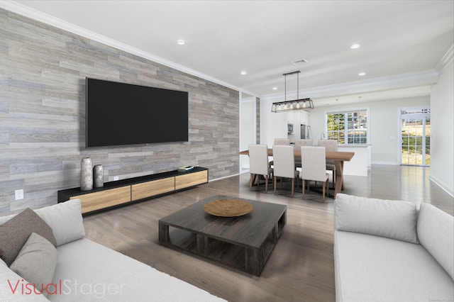 living room featuring an accent wall, wood finished floors, recessed lighting, and ornamental molding