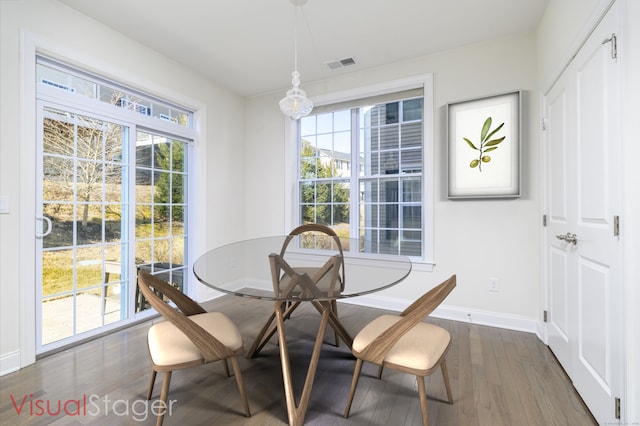 dining area with dark wood-style floors, visible vents, and baseboards