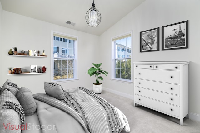 bedroom with visible vents, baseboards, lofted ceiling, light colored carpet, and a chandelier