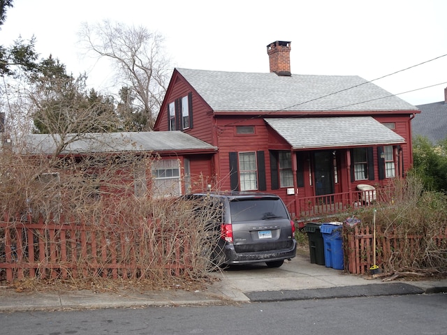 view of front of house with roof with shingles and a chimney