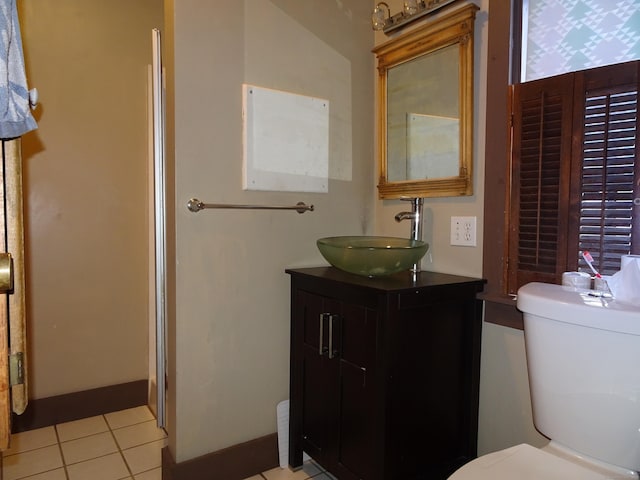 bathroom with toilet, vanity, baseboards, and tile patterned floors