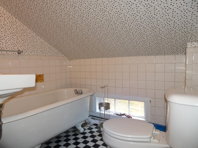 full bathroom with toilet, a bathing tub, tile walls, and tile patterned floors