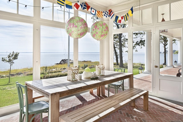 sunroom featuring a water view