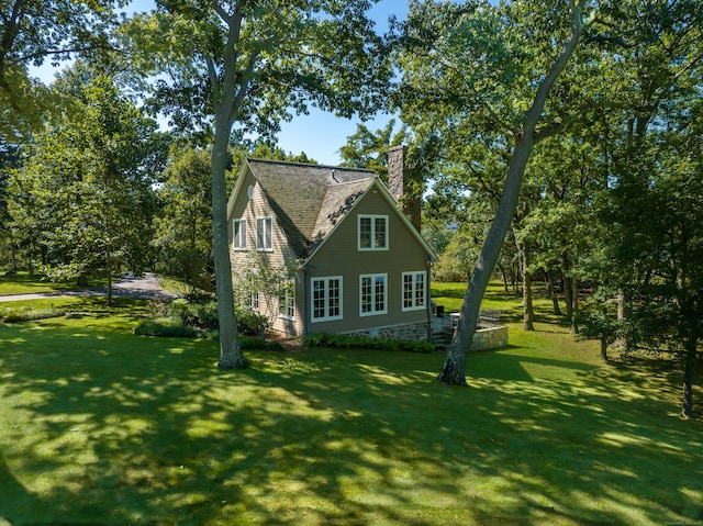 view of home's exterior featuring a lawn and a chimney