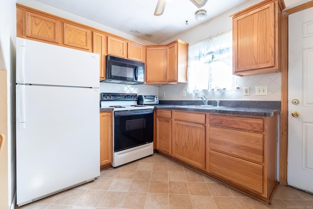 kitchen featuring dark countertops, white appliances, backsplash, and a sink