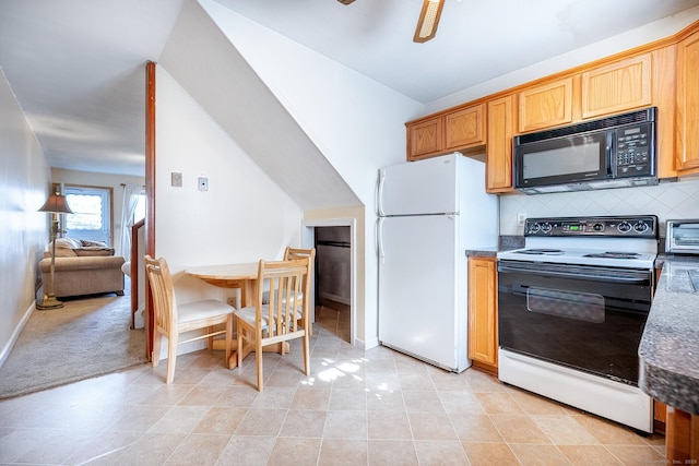 kitchen featuring black microwave, a ceiling fan, electric stove, backsplash, and freestanding refrigerator