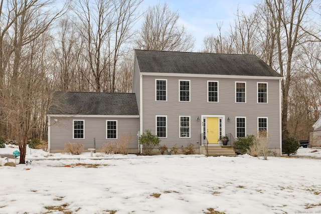 colonial house featuring roof with shingles