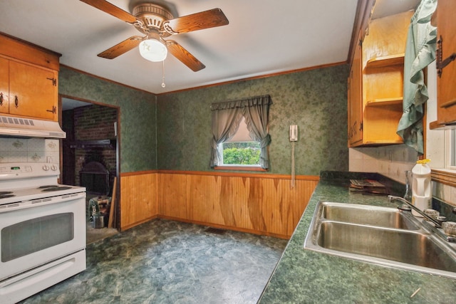 kitchen with under cabinet range hood, wainscoting, ceiling fan, a sink, and electric range