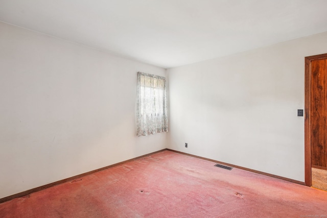 carpeted empty room featuring baseboards