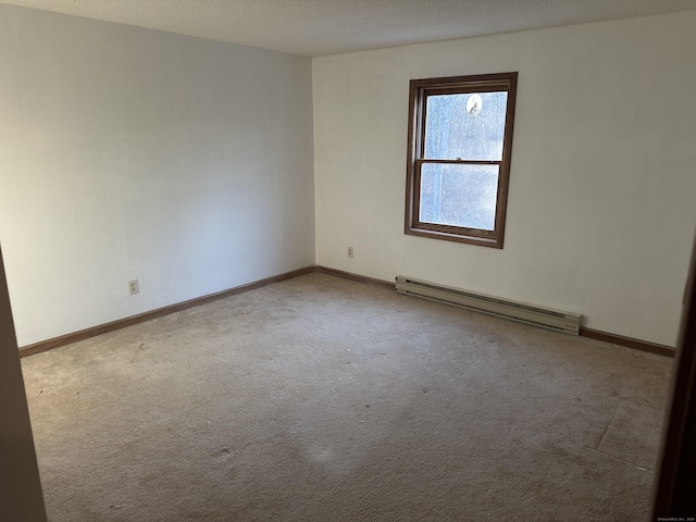 empty room featuring baseboard heating, carpet, and baseboards