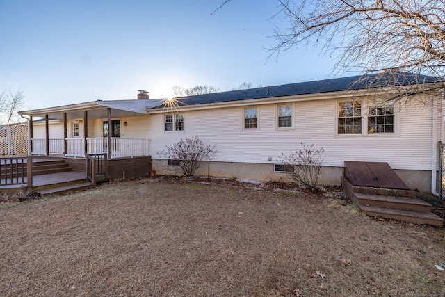 back of house featuring crawl space and a chimney