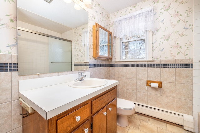 bathroom with vanity, wallpapered walls, a baseboard heating unit, tile walls, and toilet