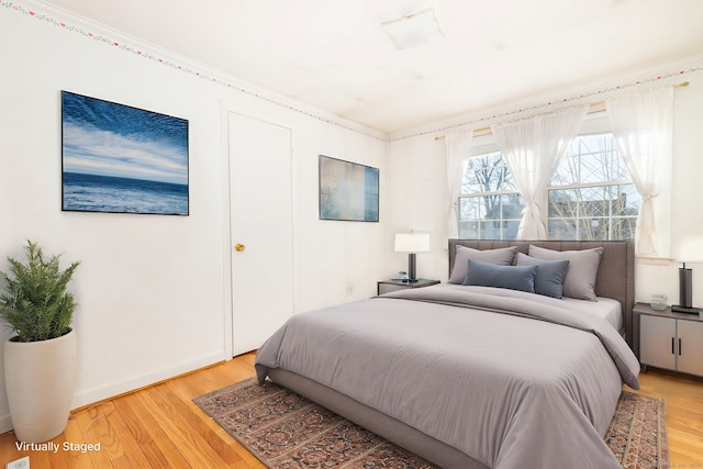 bedroom featuring light wood-style flooring and baseboards