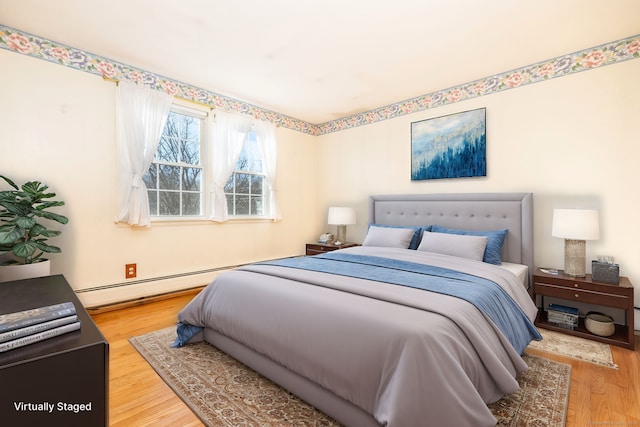 bedroom featuring wood finished floors and baseboard heating