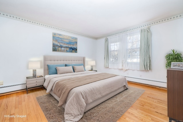 bedroom featuring a baseboard heating unit and wood finished floors