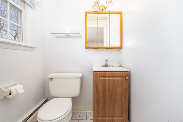 bathroom featuring a baseboard heating unit, baseboards, toilet, and vanity