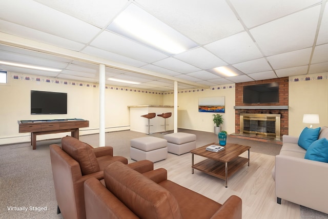 living room with a fireplace, a paneled ceiling, and a baseboard radiator