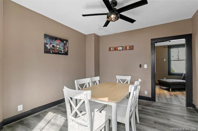 dining room featuring wood finished floors, a ceiling fan, and baseboards