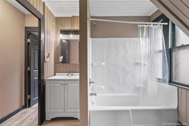 bathroom featuring wood walls, wood finished floors, shower / tub combo with curtain, and vanity