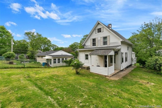 back of house featuring fence and a yard