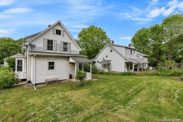 back of property with central AC and a yard