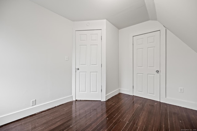 additional living space with dark wood-style flooring, baseboards, and lofted ceiling