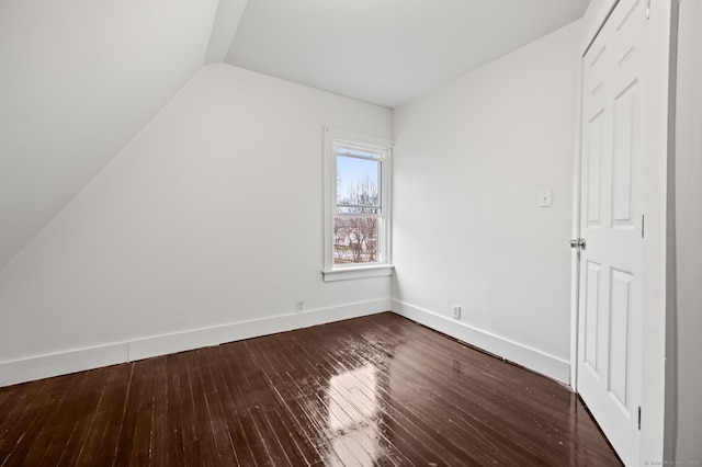 bonus room featuring baseboards, dark wood-style floors, and vaulted ceiling