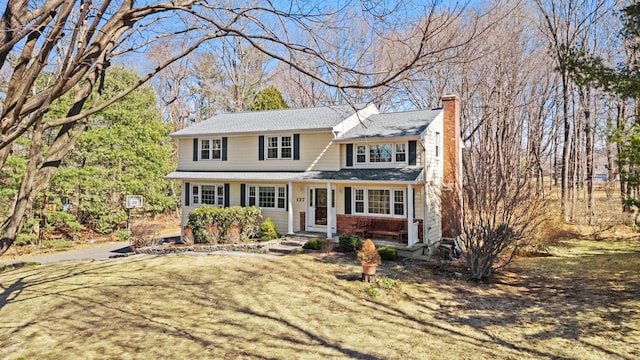 view of front of house with brick siding and a chimney