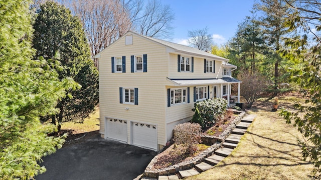 view of front facade featuring a garage, a porch, and driveway