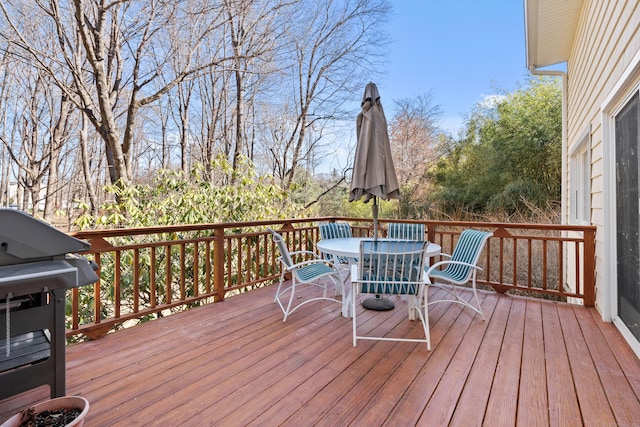 deck featuring outdoor dining space and grilling area