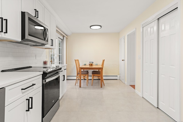 kitchen featuring white cabinetry, stainless steel microwave, tasteful backsplash, and electric range oven