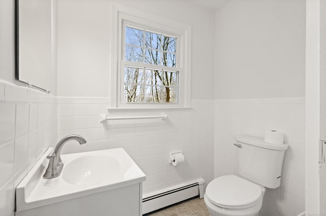 bathroom featuring a baseboard heating unit, a wainscoted wall, toilet, tile patterned floors, and vanity