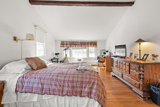 bedroom featuring beam ceiling, wood finished floors, and high vaulted ceiling