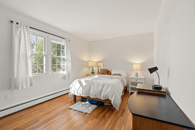 bedroom with baseboard heating and hardwood / wood-style flooring