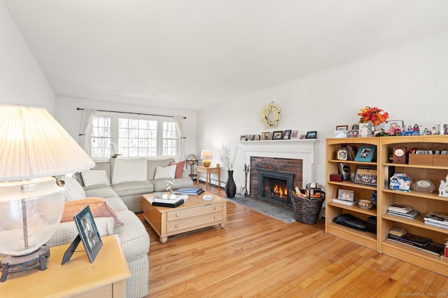 living area featuring a brick fireplace and wood finished floors