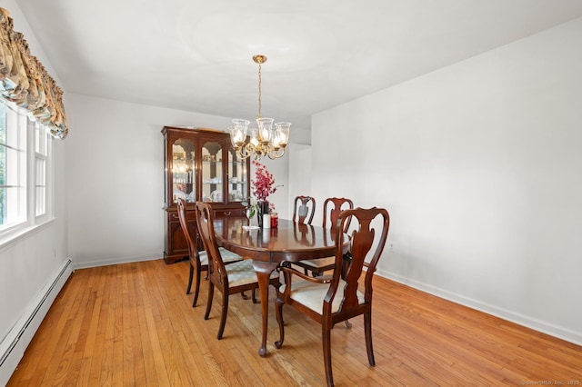 dining room with a chandelier, baseboards, light wood-style floors, and a baseboard radiator