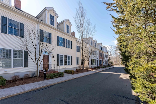 exterior space with a residential view, curbs, and sidewalks