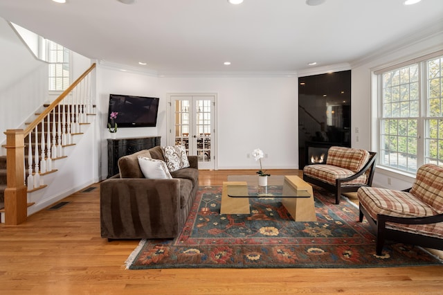 living room featuring wood finished floors, recessed lighting, crown molding, baseboards, and stairs