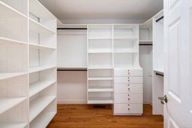 spacious closet featuring visible vents and wood finished floors